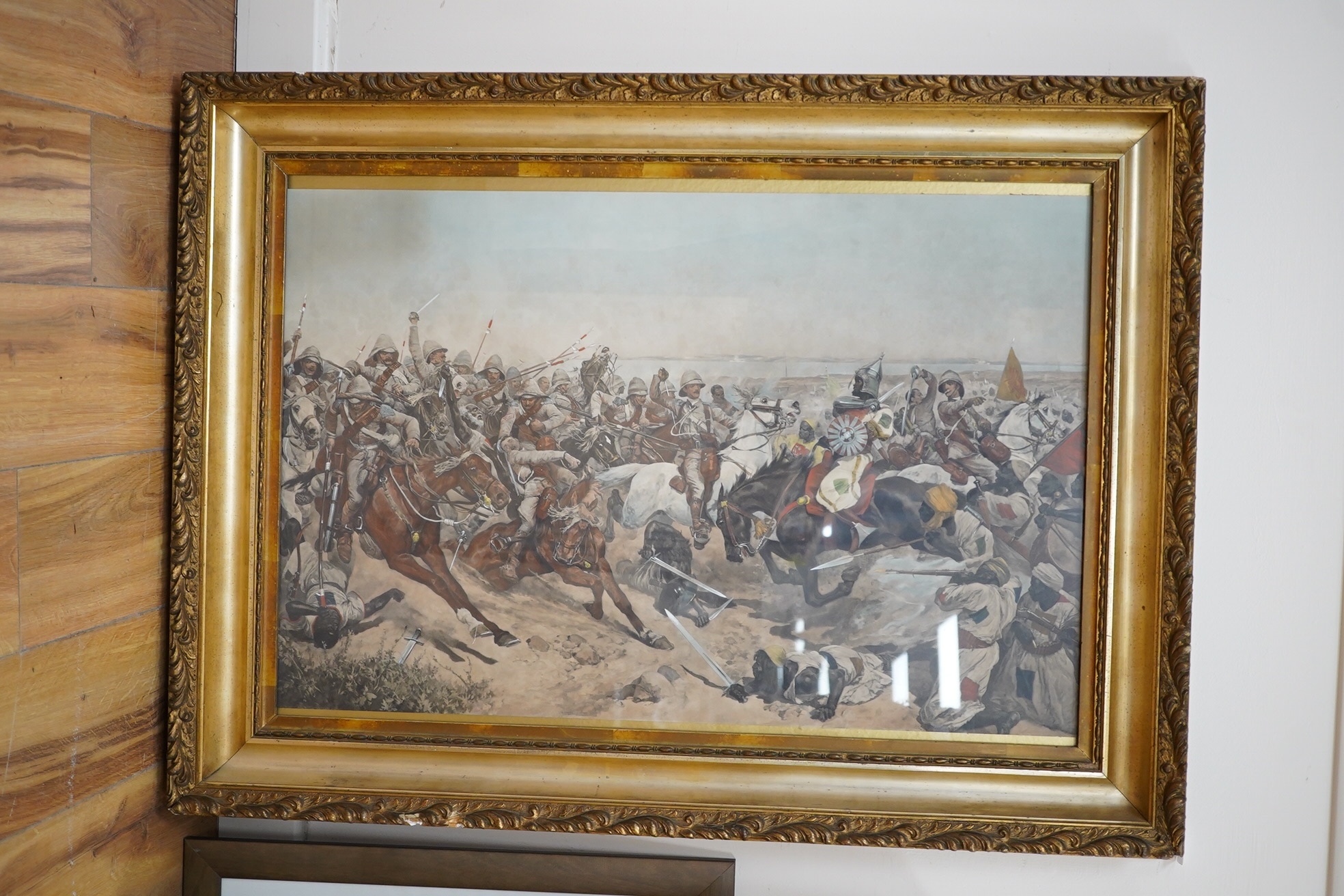 After Edward Matthew Hale (1852-1924), overpainted colour print, The charge of the 21st Lancers in September 1898, heavy gilt frame, 53x80cm. Condition - some damage/loss to frame